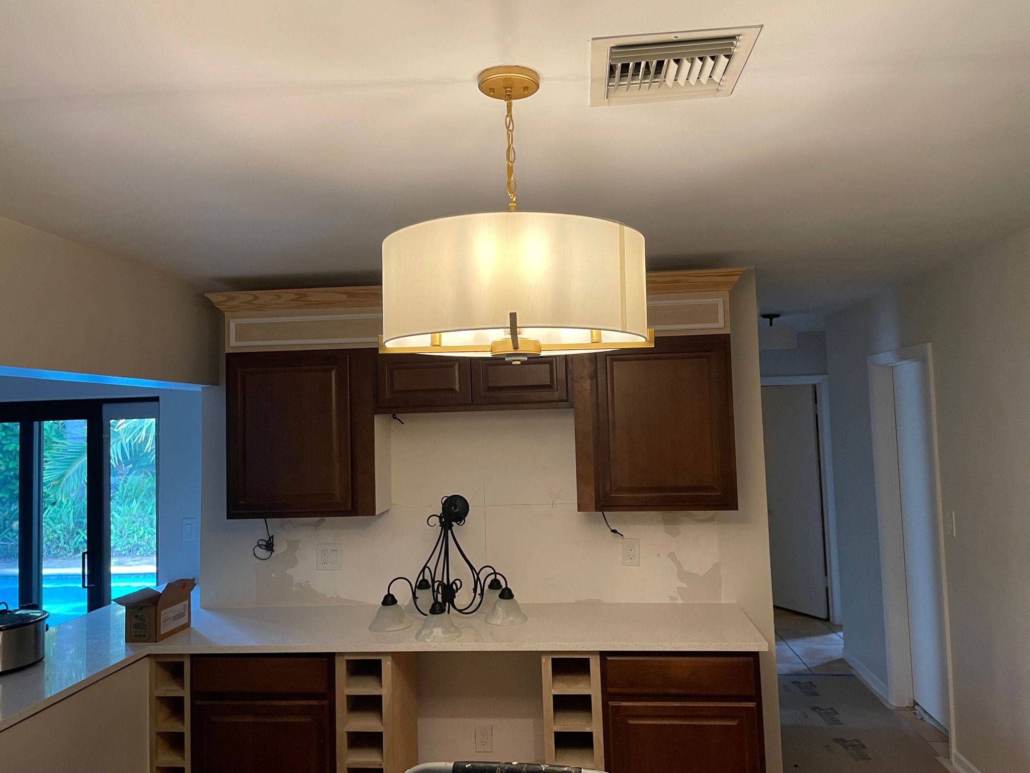Chandelier install completed by Kalif Edwin in a South Florida home overlooking the pool